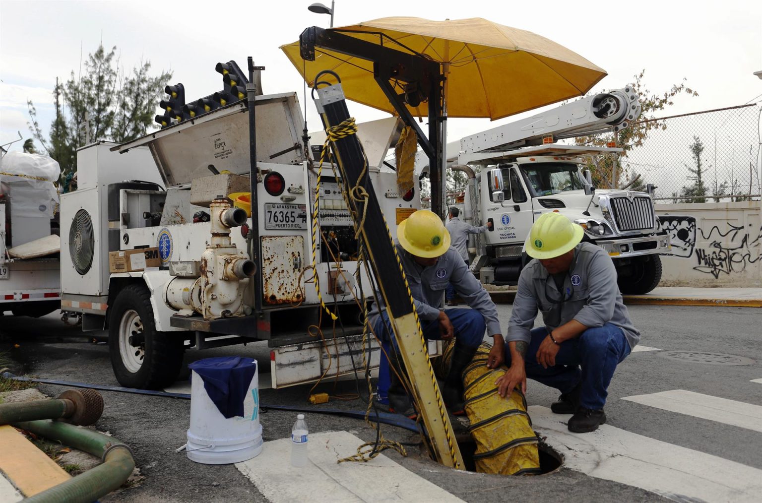 Los empleados de la Autoridad de Energía Eléctrica de Puerto Rico, Agustín Rosado (i) y Pedro Andújar (d), aprovechan un apagón general para reparar una línea dañada en San Juan (Puerto Rico). Imagen de archivo. EFE/Thais Llorca