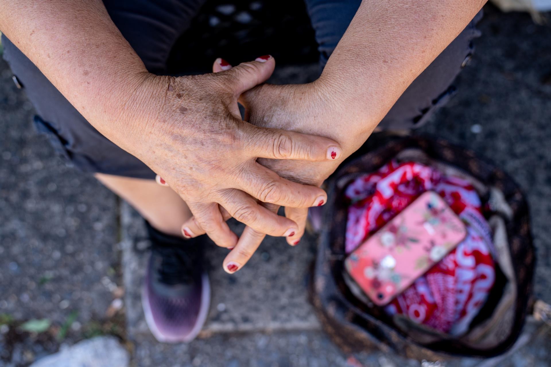 Detalle de las manos de una jornalera de limpieza sentada mientras espera ser contratadas para trabajos de limpieza, el 29 de junio de 2022 en la plaza de un vecindario judío hasídico de Brooklyn en Nueva York (EE. UU). EFE/Ángel Colmenares
