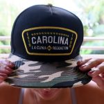 Una mujer muestra hoy una gorra con el nombre de "Carolina", municipio considerado como la cuna del reguetón, en San Juan (Puerto Rico). EFE/Jorge Muñiz