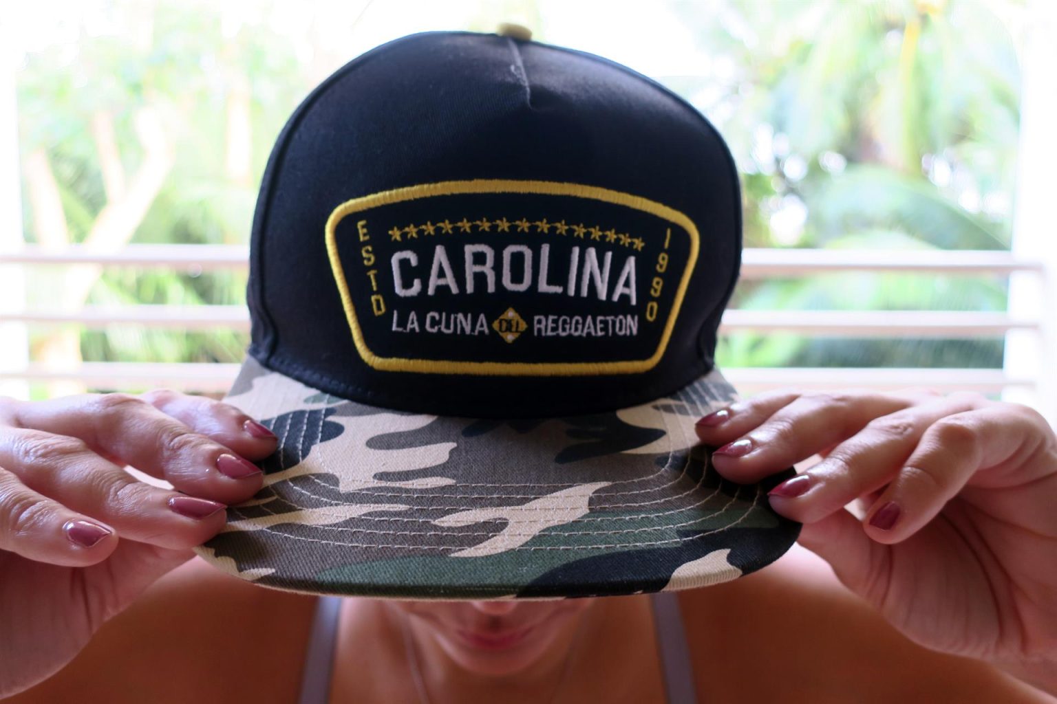 Una mujer muestra hoy una gorra con el nombre de "Carolina", municipio considerado como la cuna del reguetón, en San Juan (Puerto Rico). EFE/Jorge Muñiz