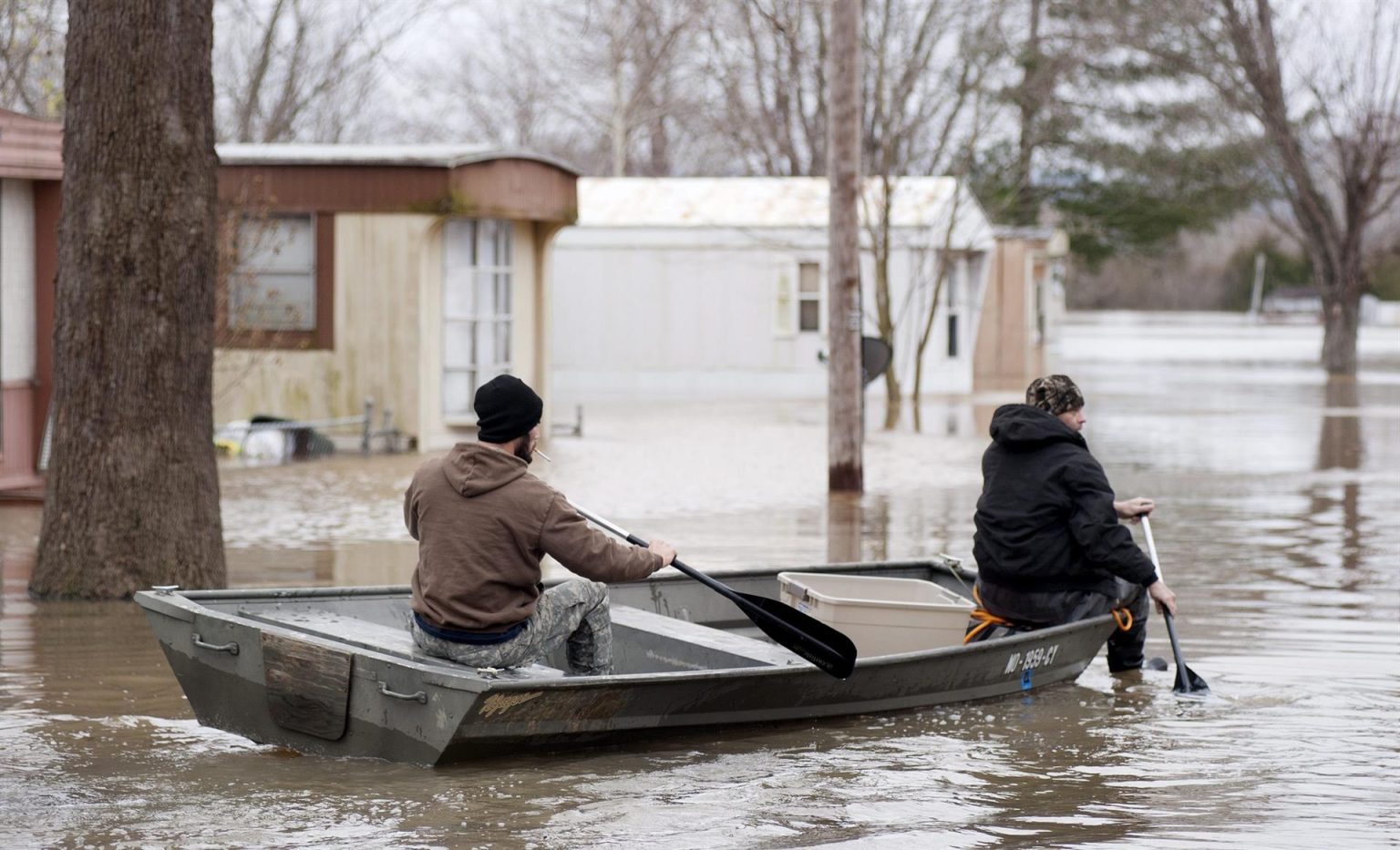 Imagen de archivo que muestra a vecinos utilizando una barca para inspeccionar las zonas inundadas por las aguas en Misuri, Estados Unidos. EFE/Sid Hastings