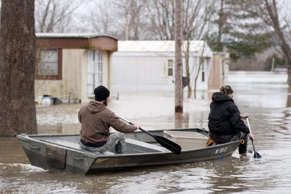 Imagen de archivo que muestra a vecinos utilizando una barca para inspeccionar las zonas inundadas por las aguas en Misuri, Estados Unidos. EFE/Sid Hastings