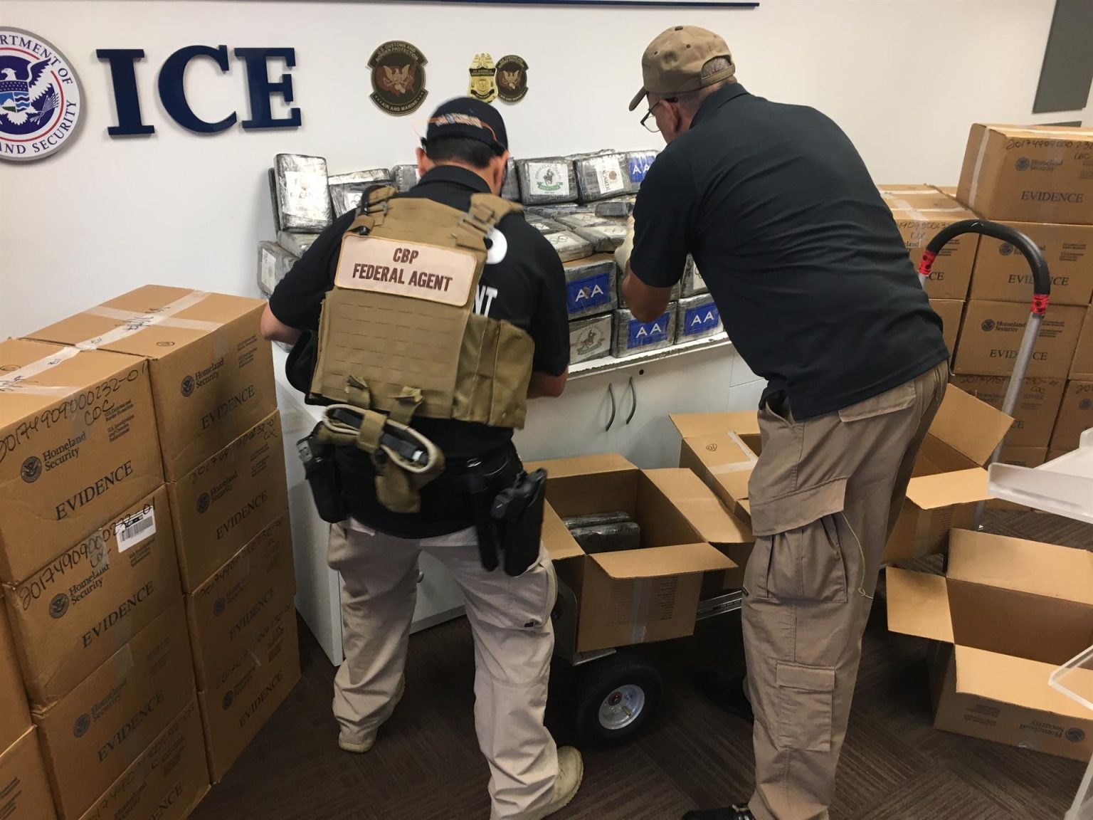 Imagen de archivo que muestra a dos funcionarios del Servicio de Aduanas y Fronteras de Estados Unidos colocando varios paquetes de cocaína decomisados en la oficina del ICE en San Juan (Puerto Rico). EFE/Jorge Muñiz
