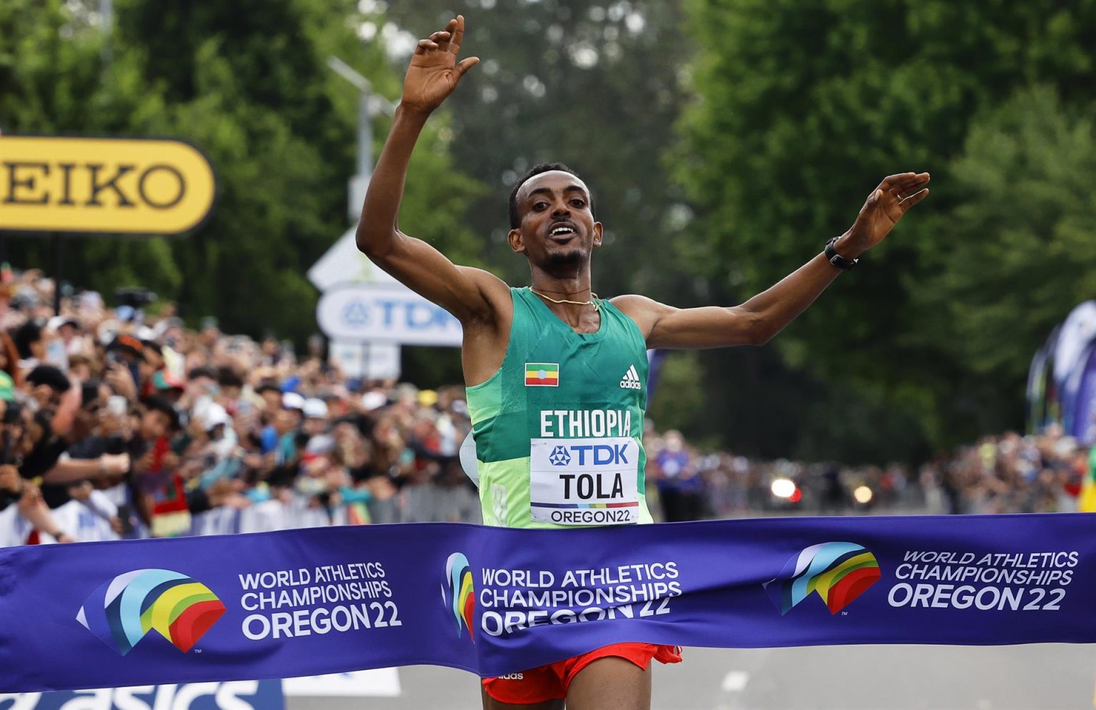 El fondista etiopeTamirat Tola (c) fue registrado al cruzar victorioso la meta del maratón de los Campeonatos Mundiales de Atletismo, en Eugene (Oregon, EE.UU.).EFE/Erik S. Lesser