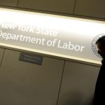Imagen de archivo que muestra a un hombre pasar ante un letrero en una oficina del Departamento de Trabajo de Nueva York, Estados Unidos. EFE/Justin Lane