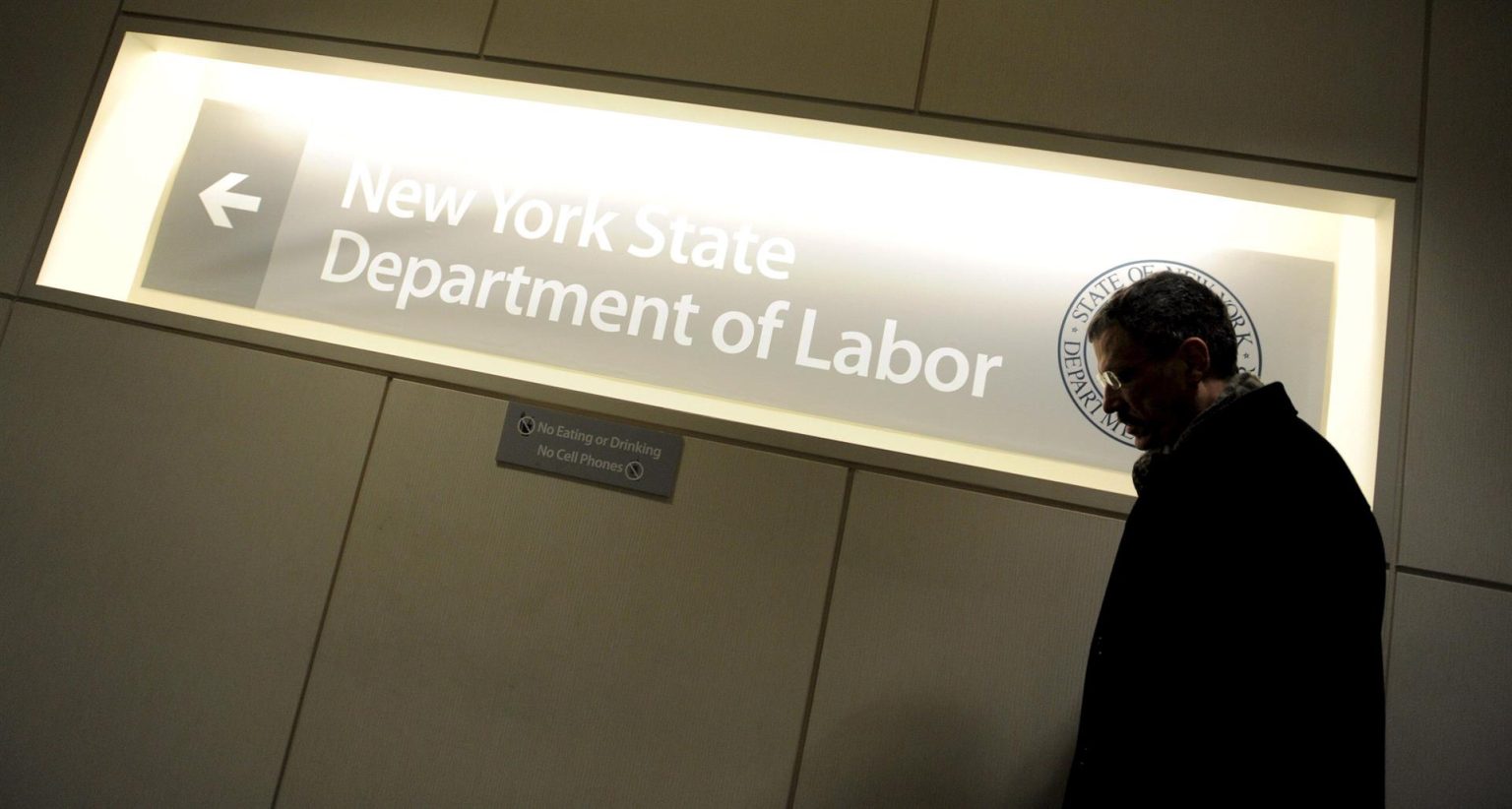 Imagen de archivo que muestra a un hombre pasar ante un letrero en una oficina del Departamento de Trabajo de Nueva York, Estados Unidos. EFE/Justin Lane