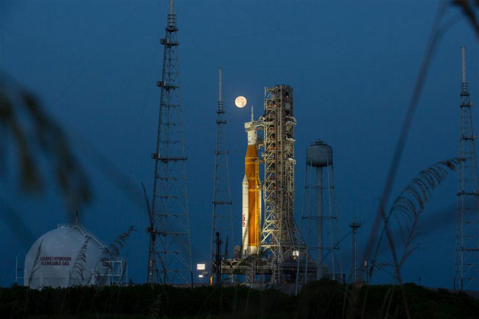 Fotografía del 14 de junio de 2022, cedida por la NASA, donde se aprecia la luna llena detrás del cohete del Sistema de lanzamiento espacial (SLS) Artemis I que lleva en lo alto la nave espacial Orion, en el Complejo de Lanzamiento 39B del Centro Espacial Kennedy, en Merritt Island, Florida (EE.UU.). EFE/ NASA/ SÓLO USO EDITORIAL/SÓLO DISPONIBLE PARA ILUSTRAR LA NOTICIA QUE ACOMPAÑA (CRÉDITO OBLIGATORIO)