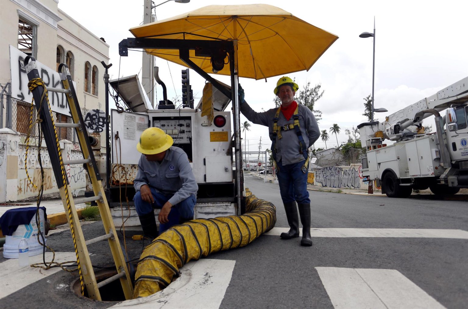 Fotografía de archivo de los empleados de la Autoridad de Energía Eléctrica de Puerto Rico, Agustín Rosado (i) y Pedro Andújar (d), quienes aprovechan un apagón general para reparar una línea dañada, en San Juan (Puerto Rico). EFE/Thais Llorca