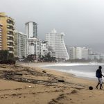 Una persona camina por una playa llena de basura debido a las fuertes lluvias en Acapulco, estado de Guerrero (México). Imagen de archivo. EFE/ David Guzmán