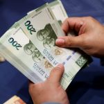 Fotografía de archivo de una mujer mostrando el nuevo billete de 200 pesos en Ciudad de México (México). EFE/ José Méndez