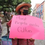 Una mujer indígena, artesana y un grupo de colectivos de artesanos, protestan afuera de una tienda de ropa para exigir un alto a la apropiación cultural de sus textiles en municipio de Mitla, en el estado de Oaxaca (México). EFE/Daniel Ricardez