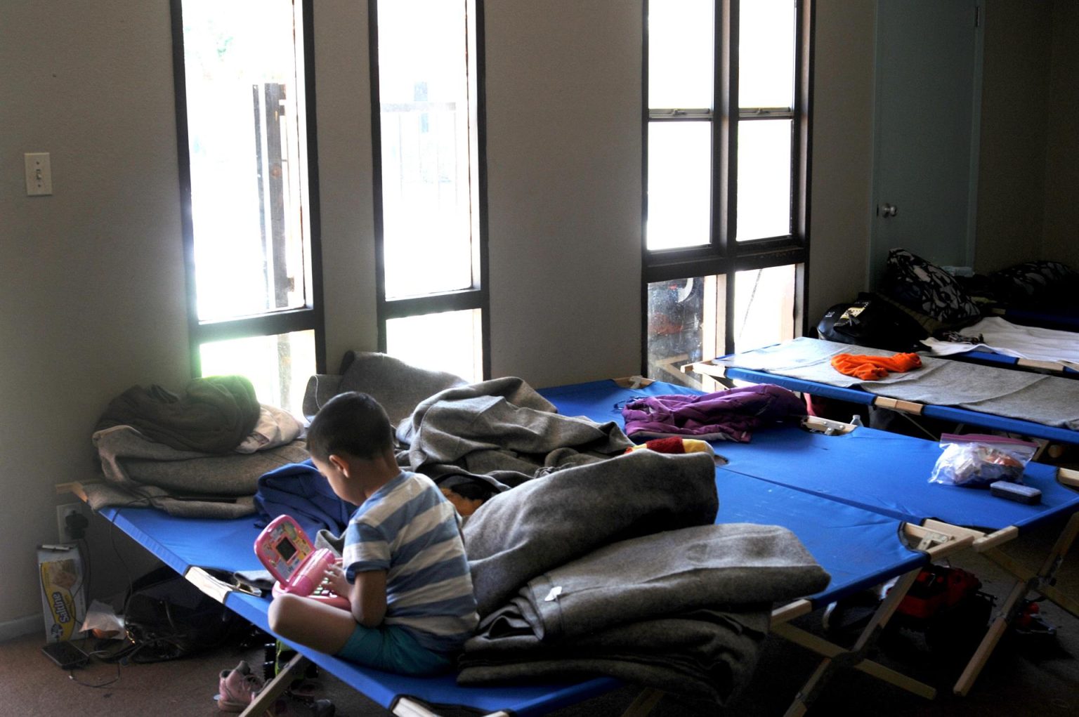 Fotografía de archivo donde aparece un niño de familias de inmigrantes rescatados de las calles mientras juega sobre una cama en una habitación dentro de la iglesia Monte Vista en Phoenix, Arizona. EFE/Beatriz Limón