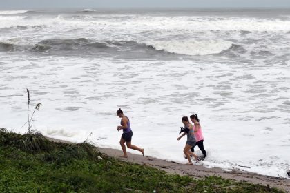 Curiosos caminan cerca de las olas en el paseo marítimo de Juno Beach, Florida (Estados Unidos). Imagen de archivo EFE/ Jim Rassol