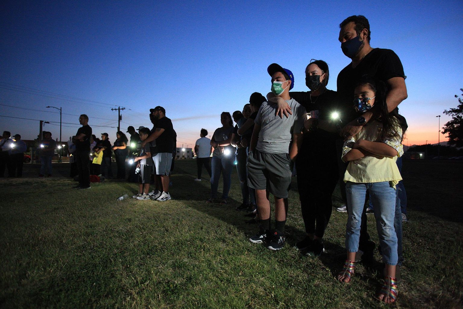 Fotografía de varias personas que participan en una vigilia en memoria de las víctimas del tiroteo en una escuela en Uvalde, en El Paso (Texas). EFE/ Luis Torres