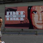 Un hombre camina frente a un mural con la imagen de Álex Saab. Fotografía de archivo. EFE/ Rayner Peña R.