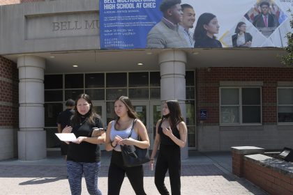 Una mujer y sus hijas salen de la Escuela Multicultural Secundaria Bell durante el primer día de clases, el 26 de agosto de 2022, en Washington (Estados Unidos). EFE/ Lenin Nolly