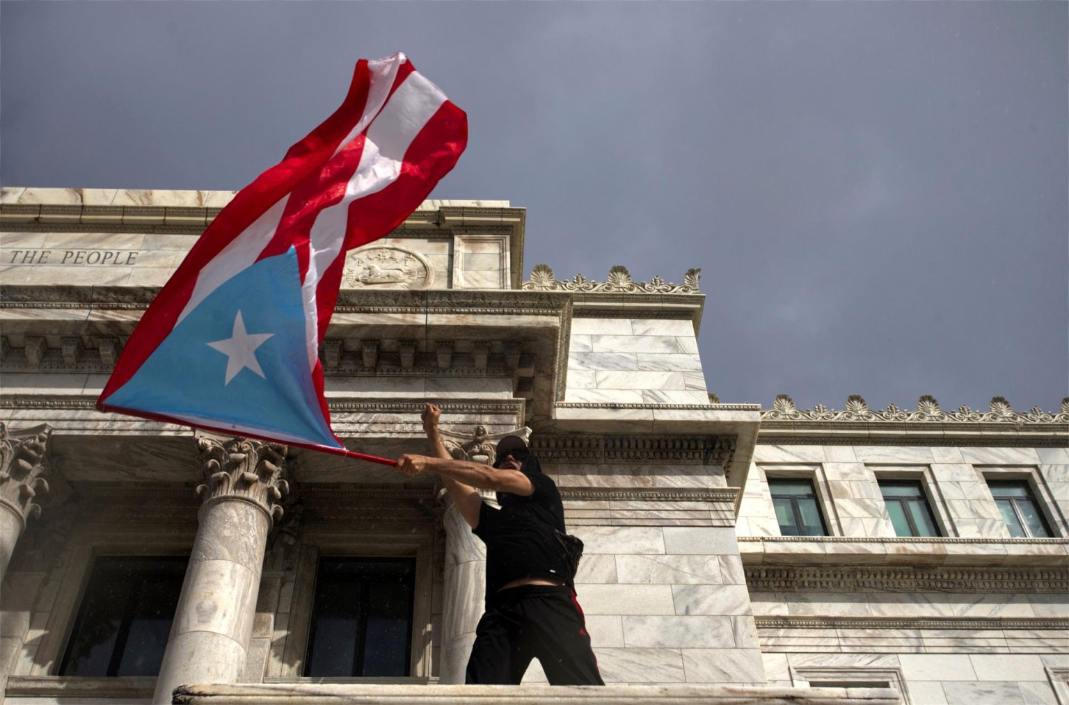 Fotografía de archivo que muestra a una persona ondeando una bandera puertorriqueña frente al Capitolio en San Juan, Puerto Rico. EFE/Thais LLorca