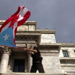 Una persona ondea una bandera puertorriqueña frente al Capitolio durante una manifestación en San Juan, Puerto Rico. Imagen de archivo. EFE/Thais LLorca