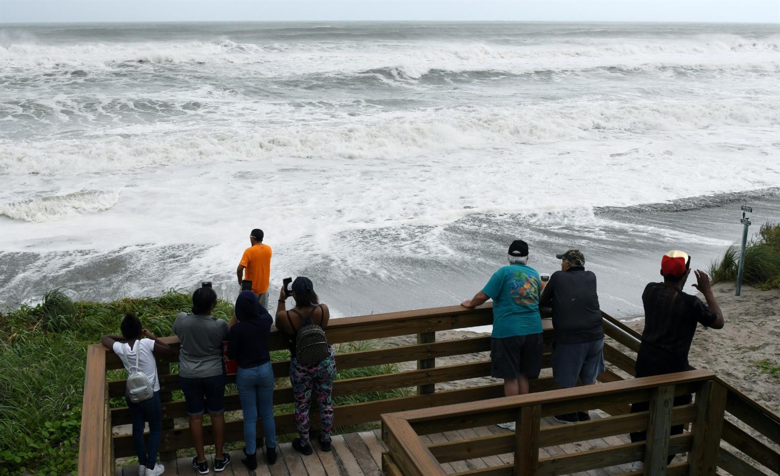 Curiosos observan las olas que causa el huracán Dorian en el paseo marítimo de Juno Beach, Florida (Estados Unidos). Imagen de archivo. EFE/ Jim Rassol