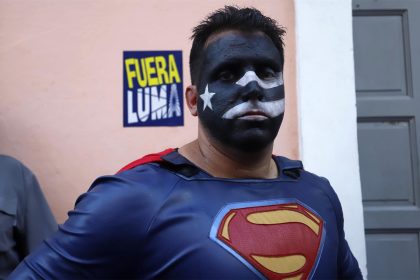 Un hombre con el rostro pintado de la bandera puertorriqueña en negro y disfrazado de Superman participa en una protesta en contra de Luma Energy, la empresa privada encargada de la transmisión y distribución de la electricidad en Puerto Rico, hoy, frente a la Fortaleza, sede del Ejecutivo en San Juan (P.Rico). EFE/ Thais Llorca