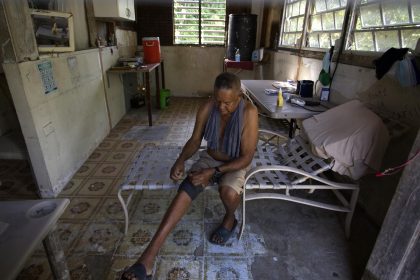 Fotografía del 13 de septiembre de 2022 donde aparece Félix Calderón mientras descansa en una parte de su casa afectada por el paso en el 2017 del huracán María por Canóvanas, Puerto Rico. EFE/Thais Llorca