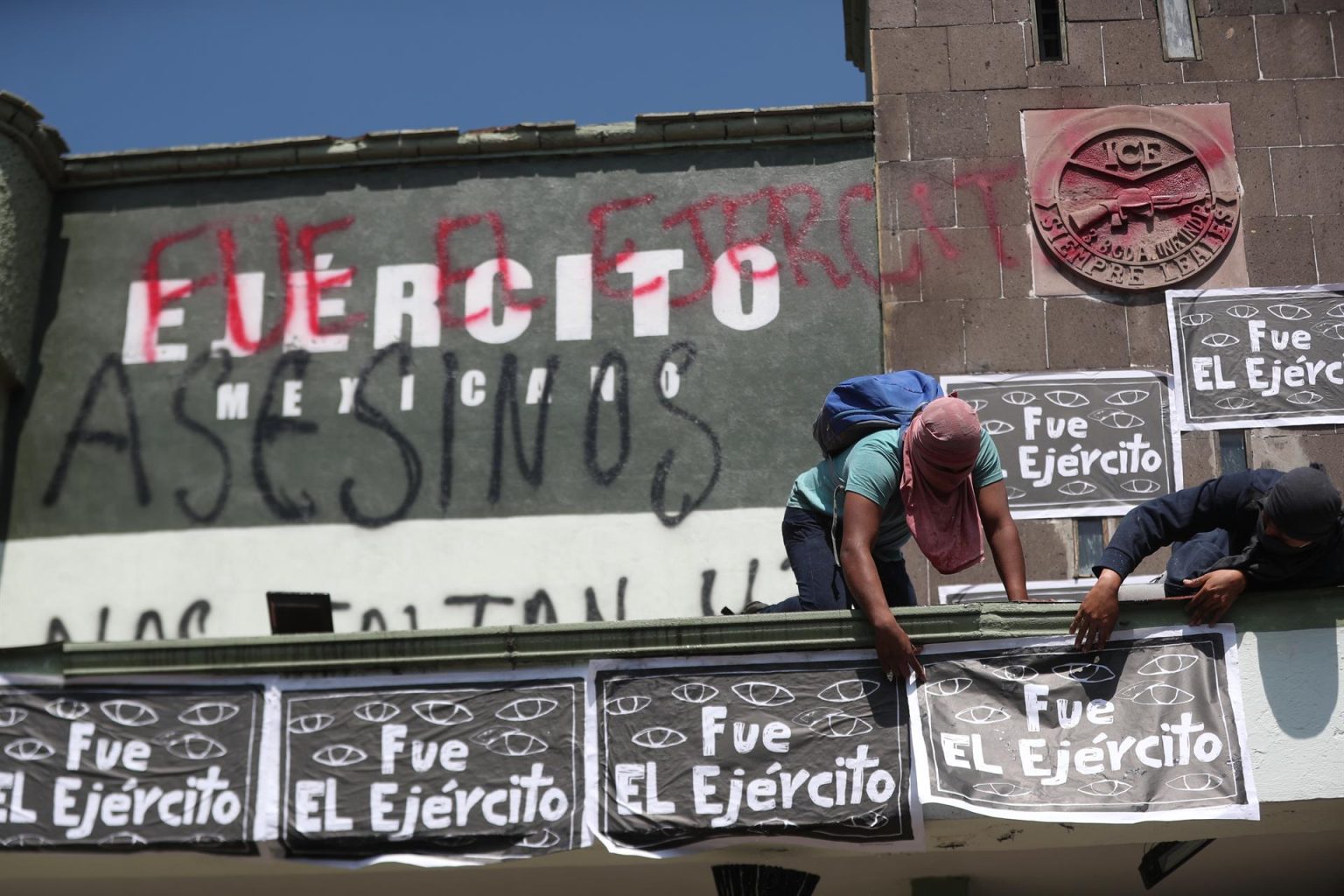 Dos hombres colocan carteles durante una manifestación por los 43 estudiantes desaparecidos de la Escuela Normal "Isidro Burgos" de Ayotzinapa, en el estado de Guerrero, hoy, en el Campo Militar Número 1., en la Ciudad de México (México). EFE/ Sáshenka Gutiérrez