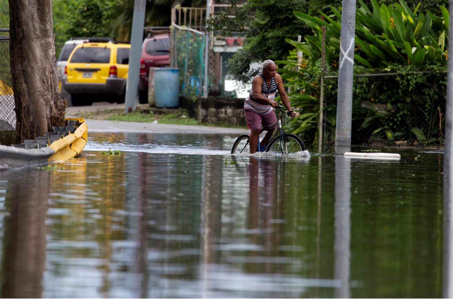 Fotografía de archivo de un hombre que cruza en bicicleta una calle inundada debido a las intensas lluvias registradas en Cataño (Puerto Rico). EFE/ Thais LLorca