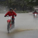 Motociclistas cruzan una calle inundada debido a lluvias por el paso del huracán Fiona hoy, en Toa Baja (Puerto Rico). EFE/Thais LLorca