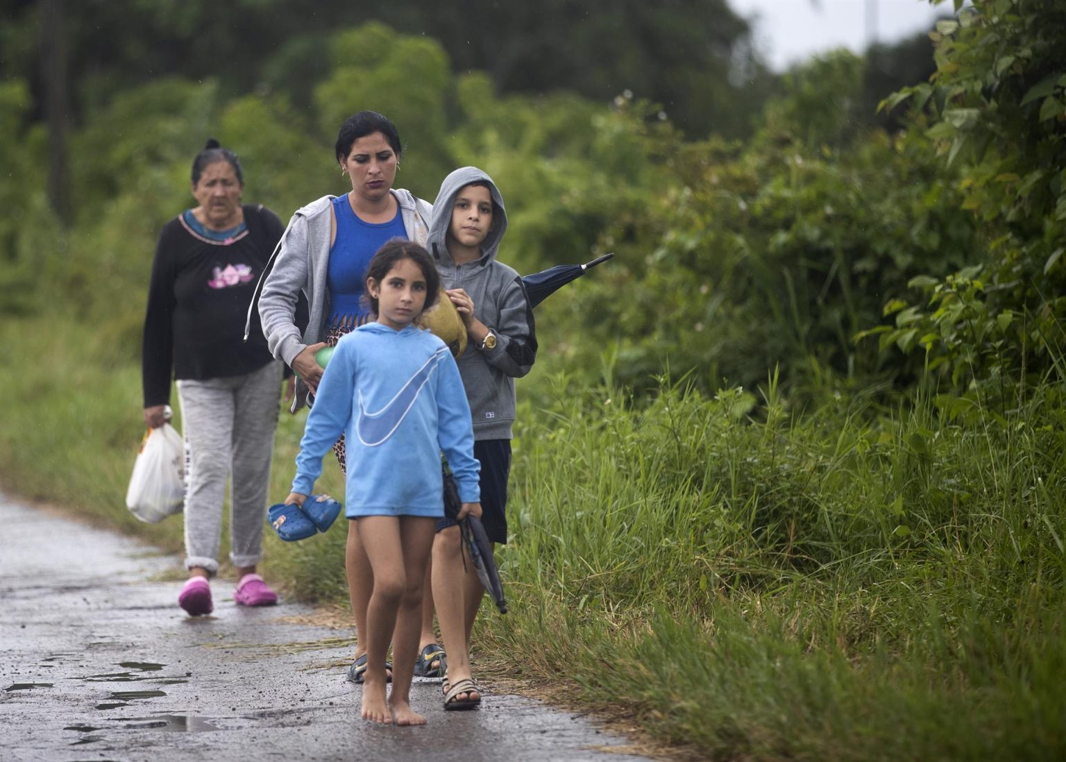 Varias personas caminan por una de las calles de Coloma, poblado de la provincia Pinar del Río por la que está previsto entrará el huracán Ian, hoy en Pinar del Río (Cuba). EFE/Yander Zamora