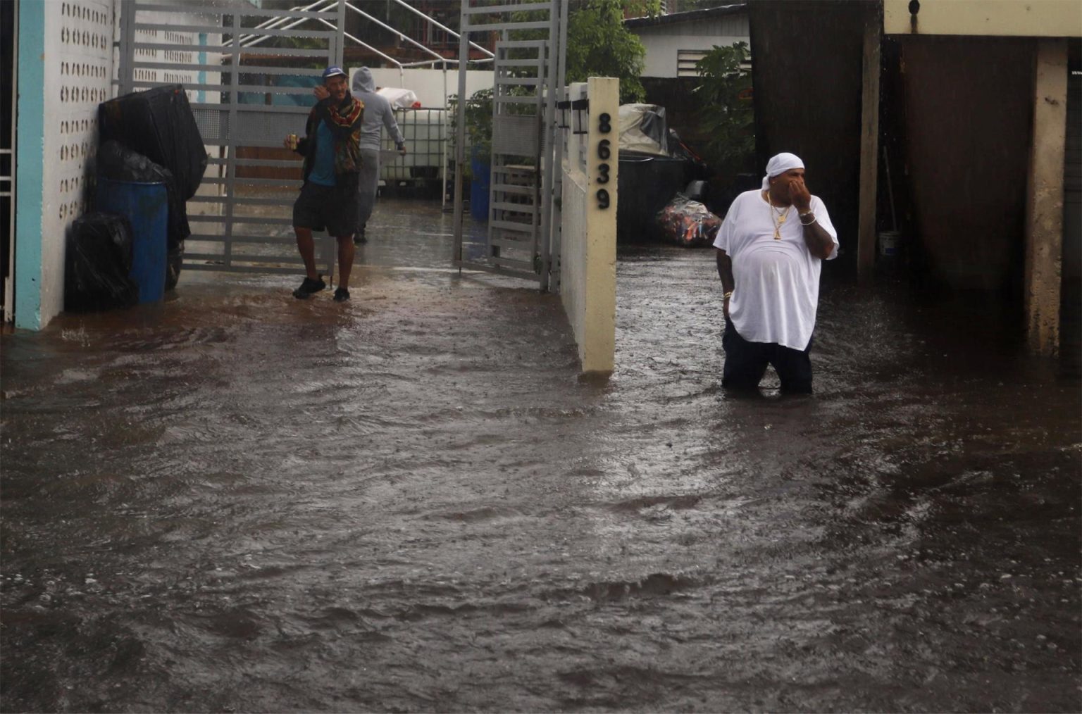 Personas caminan en una calle inundada debido a lluvias ocasionadas por el paso del huracán Fiona en Toa Baja (Puerto Rico). EFE/Thais LLorca