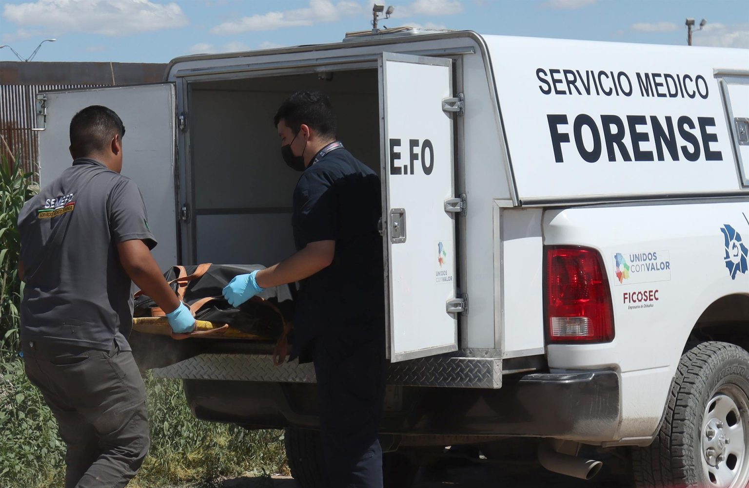 Personal del servicio medico forense, levantan el cuerpo de un migrante hoy en las orillas del rio Bravo en Ciudad Juárez, estado de Chihuahua (México). EFE/ Luis Torres.