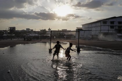 Fotografía de archivo de dos niños indonesios mientras juegan en un charco, en un barrio contaminado en la zona costera de Muara Baru, en el norte de Yakarta (Indonesia). Imagen de archivo. EFE/MAST IRHAM