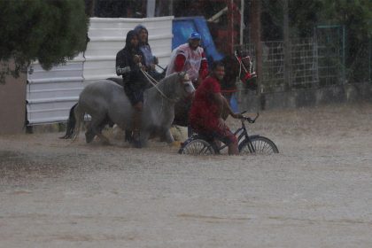 Hombres a caballo observan desde una calle inundada debido a lluvias por el paso del huracán Fiona en Toa Baja (Puerto Rico). EFE/Thais LLorca