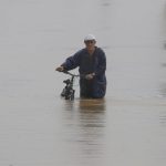 Un hombre cruza con su bicicleta una calle inundada debido a lluvias por el paso del huracán Fiona en Toa Baja (Puerto Rico). EFE/Thais LLorca