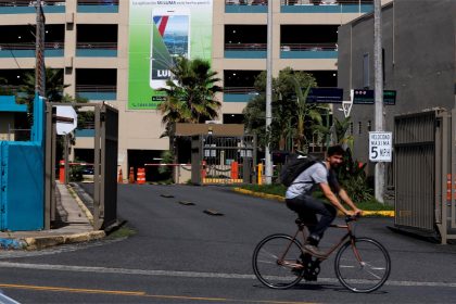 Un hombre pasa en bicicleta frente a las oficinas de Luma Energy, en el barrio de Santurce en San Juan (Puerto Rico). Imagen de archivo. EFE/Thais LLorca