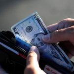 Fotografía de archivo que muestra una persona guardando en su cartera un billete de cinco dólares en Tepatitlán, estado de Jalisco (México). EFE/ Francisco Guasco