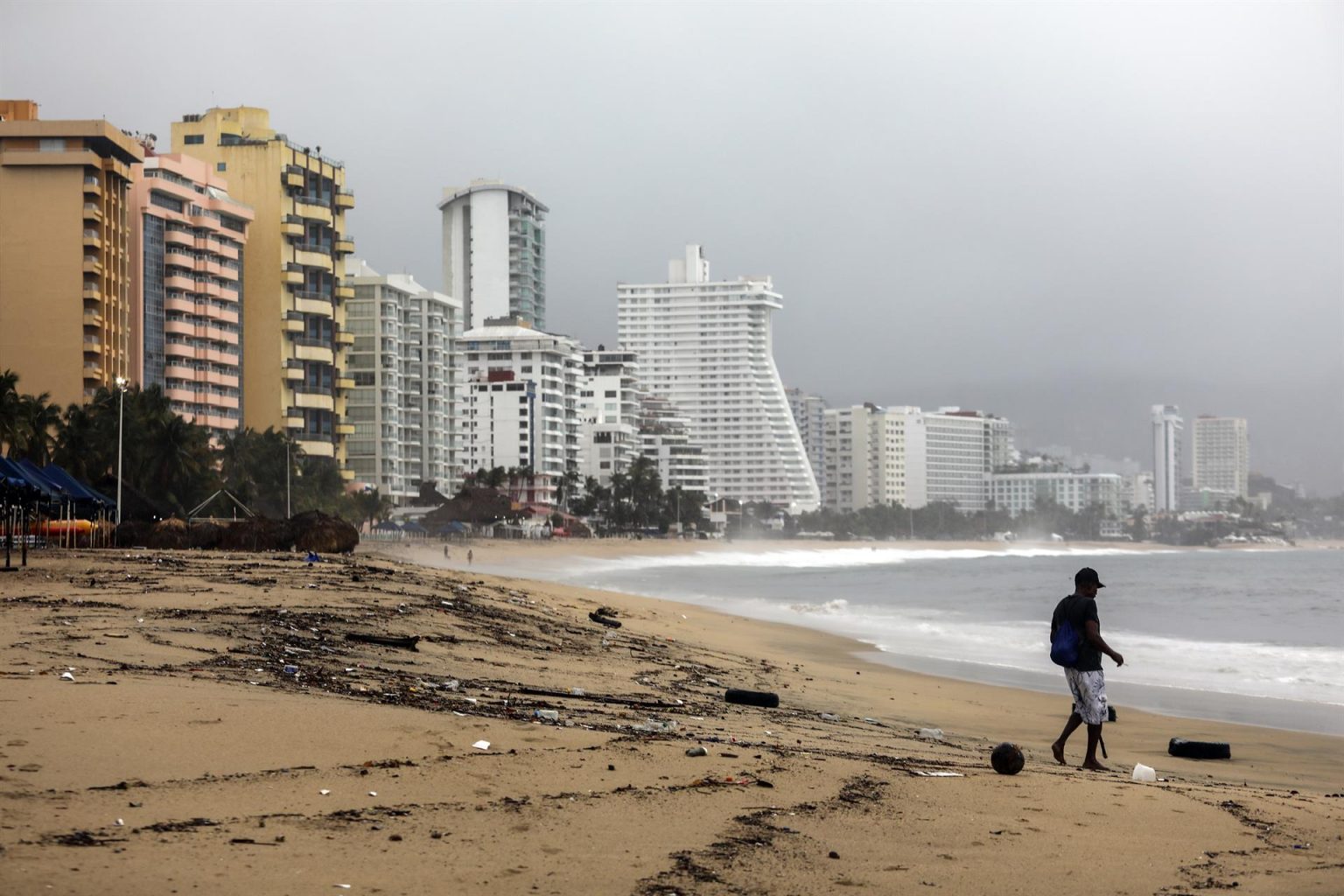 Fotografía de archivo de una persona que camina por una playa llena de basura debido a las fuertes lluvias, en el balneario de Acapulco, estado de Guerrero (México). EFE/ David Guzmán