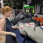 Fotografía del 31 de agosto de 2022 donde aparece la activista Anna Sacks, que se identifica en sus redes sociales como "The trash walker" (la basurera), mientras revisa unas bolsas de basura por cosas últiles en el Upper West Side, un barrio del distrito de Manhattan en Nueva York. EFE/Sarah Yáñez-Richards