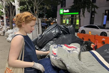 Fotografía del 31 de agosto de 2022 donde aparece la activista Anna Sacks, que se identifica en sus redes sociales como "The trash walker" (la basurera), mientras revisa unas bolsas de basura por cosas últiles en el Upper West Side, un barrio del distrito de Manhattan en Nueva York. EFE/Sarah Yáñez-Richards