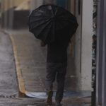 Una persona camina por la calle mientras se notan los efectos del huracán Fiona durante su paso hoy, en San Juan (Puerto Rico). EFE/ Thais Llorca