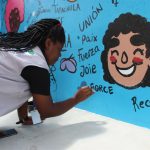 Una migrante psicóloga haitiana pinta hoy, un mural en una antigua instalación de ferrocarriles donde se ha edificado un Centro de Desarrollo Comunitario (CEDECO) en la ciudad de Tapachula, en el estado de Chiapas (México). EFE/Juan Manuel Blanco