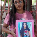 Margarita Hay Urrutia, posa con un retrato de su hermana Abigail, el 24 de agosto de 2022, en el municipio de Salina Cruz Oaxaca (México). EFE/Daniel Ricardez