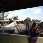 Una mujer observa una casa destruida por el paso del huracán Fiona en el vecindario de Punta Diamante en Ponce, Puerto Rico. EFE/Thais Llorca