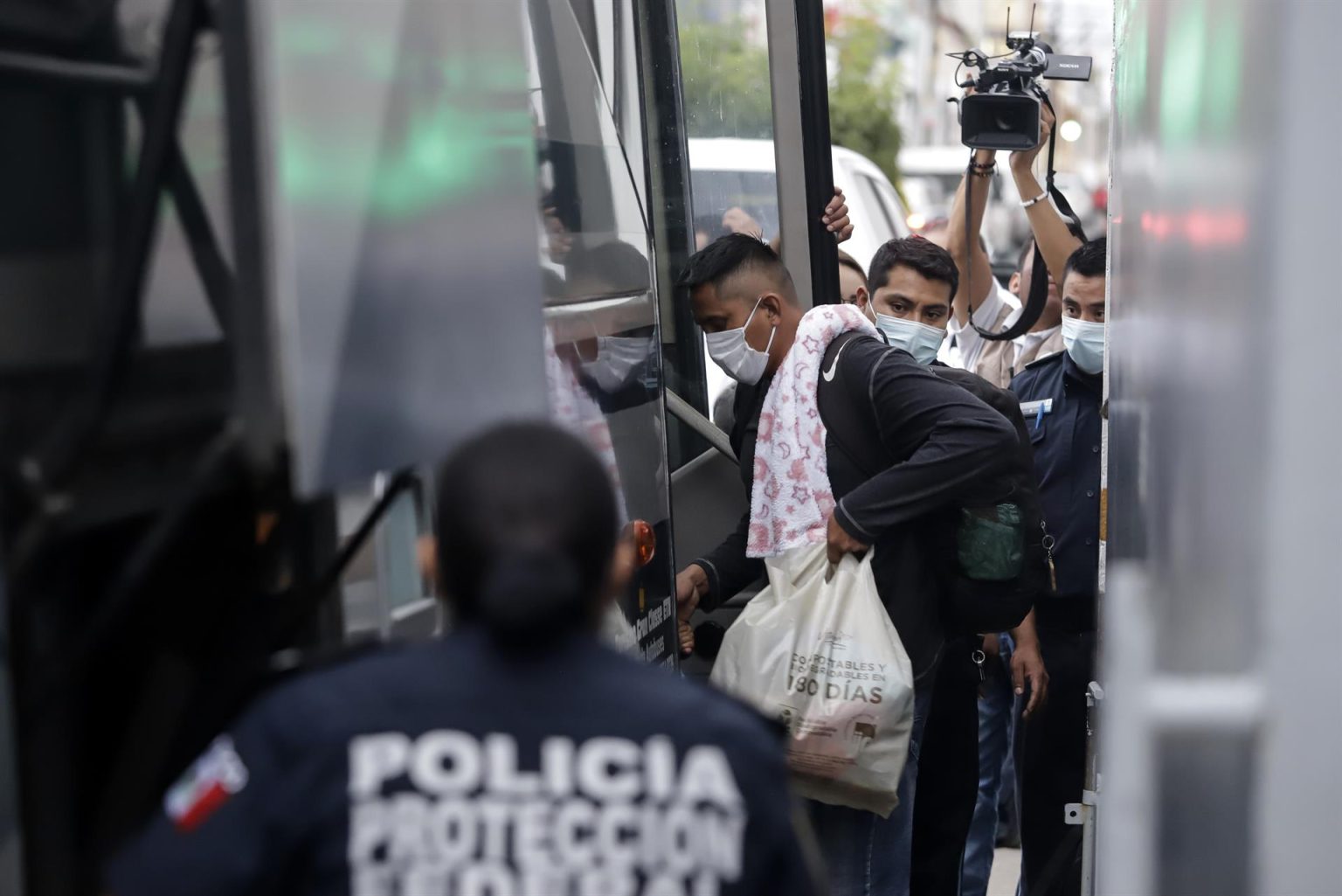 Personas migrantes suben a un autobús de pasajeros hoy, tras ser detenidos por personal del Instituto Nacional de Migración (INM) sobre la autopista en el estado de Puebla (México). EFE/ Hilda Ríos