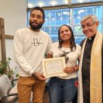 Los migrantes venezolanos Yonaiker Brujo (i) y Nathalie Quintana (c) muestran el certificado de matrimonio junto al sacerdote luterano, el padre Fabián Arias (d), hoy, en la iglesia San Pedro en Manhattan, Nueva York (EEUU). EFE/ Ruth E. Hernández