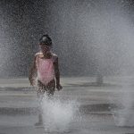 Imagen de archivo que muestra una niña refrescándose en una fuente. EFE/ Villar López