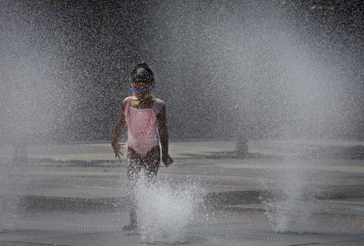 Imagen de archivo que muestra una niña refrescándose en una fuente. EFE/ Villar López