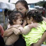 Dairana Moreno, migrante venezolana de 30 años, carga a su hija Salma Bracho (i) y otra menor, el 13 de octubre de 2022, en el pueblo de Bajo Chiquito (Panamá). EFE/ Bienvenido Velasco