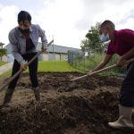 La agricultora, educadora y una de las protagonistas del documental "Serán dueñas de la tierra", Stephanie Rodríguez remueve la tierra junto a su alumno Andrew Pagán, durante su clase de agricultura en la escuela Jaime Coira el 19 de octubre 2022 en el municipio de Ciales (Puerto Rico). EFE/Thais Llorca