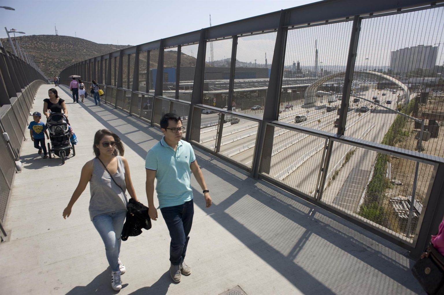 Varias personas cruzan un puente sobre la autopista sur que lleva a la garita de San Ysidro, en San Diego, California. Imagen de archivo. EFE/David Maung